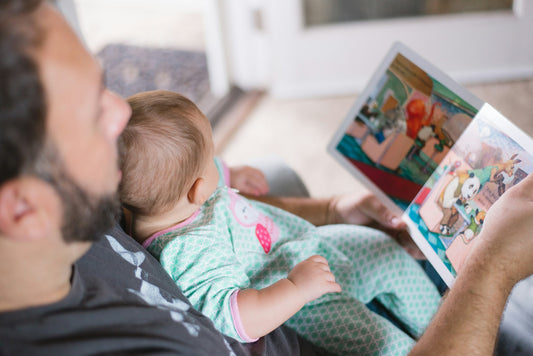 Parent reading educational book to his kid